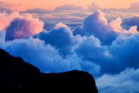 Sunrise over Haleakala National Park paints the clouds pink.