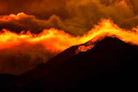 Sunrise lends fiery light to cloud cover on Haleakala Peak at Haleakala National Park in Maui, Hawaii.